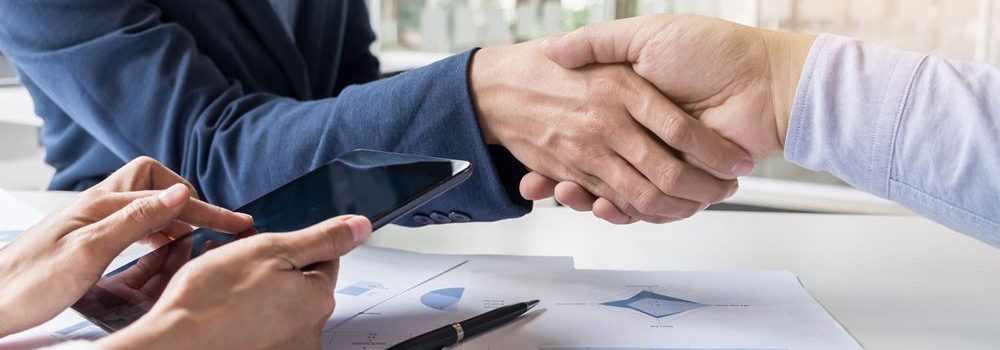 Business handshake of two men demonstrating their agreement to sign agreement or contract between their firms, companies, enterprises